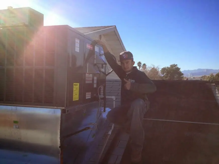 HVAC technician performing AC Tune-Up on a rooftop unit in Palm Bay